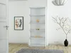 A white bookshelf in a room with a painting on the wall and a decorative tree. Produktbild-Vorschau