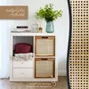 A storage unit with woven baskets and decorative items. Produktbild-Vorschau