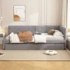 A gray upholstered daybed with a pull-out trundle bed, dressed with bedding and a throw blanket, in a bedroom setting. Produktbild-Vorschau