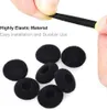 A hand is holding a black elastic band above a pile of black foam earbud covers. Produktbild-Vorschau