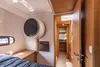 Interior view of a boat cabin, showing a small washing machine mounted on the wall. Produktbild-Vorschau