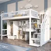 A white loft bed with a desk, wardrobe, and shelves, set up in a child's bedroom with decorative clouds on the wall. Náhled obrázku produktu