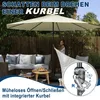 A woman is operating a patio umbrella with a crank mechanism, set in a backyard with outdoor furniture. Produktbild-Vorschau