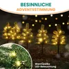 Miniature Christmas trees with LED lights in an outdoor setting at night. Produktbild-Vorschau