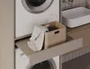 A laundry room with a washing machine, dryer, and a pull-out shelf with a basket. Produktbild-Vorschau