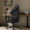 A gaming chair is set up in a home office environment with a desk, computer, and artwork. Náhled obrázku produktu