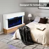 A modern electric fireplace with a white cabinet and wood base is placed in a bedroom next to a bed. A dark gray blanket is draped over the bed. Anteprima dell’immagine prodotto