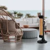 An outdoor patio scene with a heater, chair, and seating. Anteprima dell’immagine prodotto