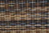 A close-up view of a woven rattan material. Produktbild-Vorschau