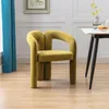 A single olive-colored velvet armchair is placed in a dining room setting next to a table. Voir les images du produit