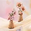 Two 3D wooden flower models in vases, with a soft, blurred background and butterflies. Náhľad obrázku produktu