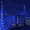 Blue LED net lights are draped over a wooden fence at night. Produktbild-Vorschau