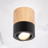 A close-up studio shot of a black and wood cylinder-shaped ceiling light. Podgląd zdjęcia produktu