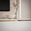 A close-up view of a modern TV cabinet with decorative items. Produktbild-Vorschau