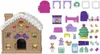 A gingerbread house playset with various accessories laid out next to it. Podgląd zdjęcia produktu