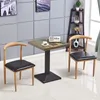 A square table with two chairs in a room with gray tiled walls. Produktbild-Vorschau