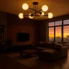 A modern living room with a sectional sofa, coffee table, and a large window overlooking a city at sunset. Náhled obrázku produktu
