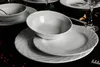 A set of white porcelain dishes arranged on a black surface. Náhľad obrázku produktu