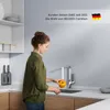 A woman is washing a yellow bell pepper under a kitchen faucet. Anteprima dell’immagine prodotto
