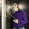 A woman is cleaning a wall with a steam cleaner. Produktbild-Vorschau
