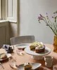 A table setting with cakes, plates, glasses, and flowers. Produktbild-Vorschau