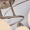 A close-up view of a ceiling light fixture, showing the brushed metal frame and glass shades. Produktbild-Vorschau