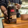 A person is holding a jar of Melitta Barista instant coffee. Produktbild-Vorschau