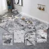 A fluffy grey rug is shown in a room setting with decorative lights and a plant. Multiple close-up views of the rug are also included. Podgląd zdjęcia produktu