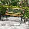 A garden bench sits on a patio in front of lush green bushes and pink flowers. Produktbild-Vorschau