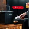 A person is holding ice cubes dispensed from an ice machine into a drink. Another drink is on the counter. A sign indicates "9 sztuk / cykl" (9 pieces / cycle). Podgląd zdjęcia produktu