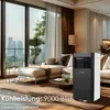 A modern living room with large windows overlooking a city skyline, featuring a sofa, coffee table, and a portable air conditioner. Voir les images du produit