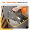 A hand is shown removing a mesh laundry bag from a multi-compartment laundry sorter. Produktbild-Vorschau