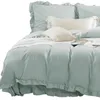A close-up view of a bed with light blue bedding and pillows. Produktbild-Vorschau