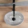 A close-up overhead view of a grey marble basin with a black faucet on a wooden countertop. Podgląd zdjęcia produktu