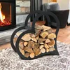 A heart-shaped metal firewood rack filled with logs is placed on a rug in front of a fireplace. Podgląd zdjęcia produktu