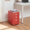 A red roll container with three drawers is placed on a wooden floor next to a white desk. White headphones and books are on top of the roll container. Anteprima dell’immagine prodotto