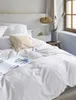 A neatly made bed with white bedding and a beige pillow. Produktbild-Vorschau