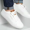 Close-up shot of a person wearing white sneakers and blue jeans. Voir les images du produit