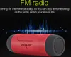 A red and black portable speaker is shown against a dark background with blue sound wave graphics. Produktbild-Vorschau