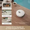 A robot vacuum cleaner is shown on a wooden floor with scattered debris, next to a bowl of pet food. The image also features three inset panels showcasing different features of the robot vacuum, including pet monitoring, dynamic cleaning around people and  Produktbild-Vorschau