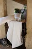 A white comforter and pillows are draped over a rustic wooden door, with a dog lying on the floor in the foreground. Produktbild-Vorschau