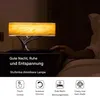 A bedside lamp with a wood-like shade is shown on a nightstand next to a bed, with a person's hand reaching towards it. The image includes text and icons describing the product's features. Produktbild-Vorschau