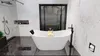 A modern bathroom with a freestanding bathtub, shower, and marble-like walls. Produktbild-Vorschau