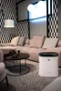A modern living room with a sectional sofa, coffee table, and an air purifier. Podgląd zdjęcia produktu