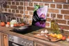 A kitchen counter with various cooking ingredients and utensils, featuring a glass cutting board with an orchid design. Náhľad obrázku produktu