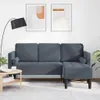 A modern living room scene featuring a dark gray sofa set with a chaise lounge and ottoman, a floor lamp, and abstract art on the wall. Produktbild-Vorschau