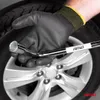 A gloved hand holds a car wheel wrench over a car wheel. Náhľad obrázku produktu
