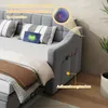 A close-up view of a grey upholstered daybed, highlighting its features like USB charging ports and storage pockets. Produktbild-Vorschau
