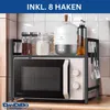 A kitchen shelf unit is placed on top of a microwave, holding various kitchen items like jars of spices, a small appliance, and utensils. Produktbild-Vorschau