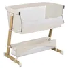 A baby bassinet with a storage basket underneath, shown against a white background. Produktbild-Vorschau